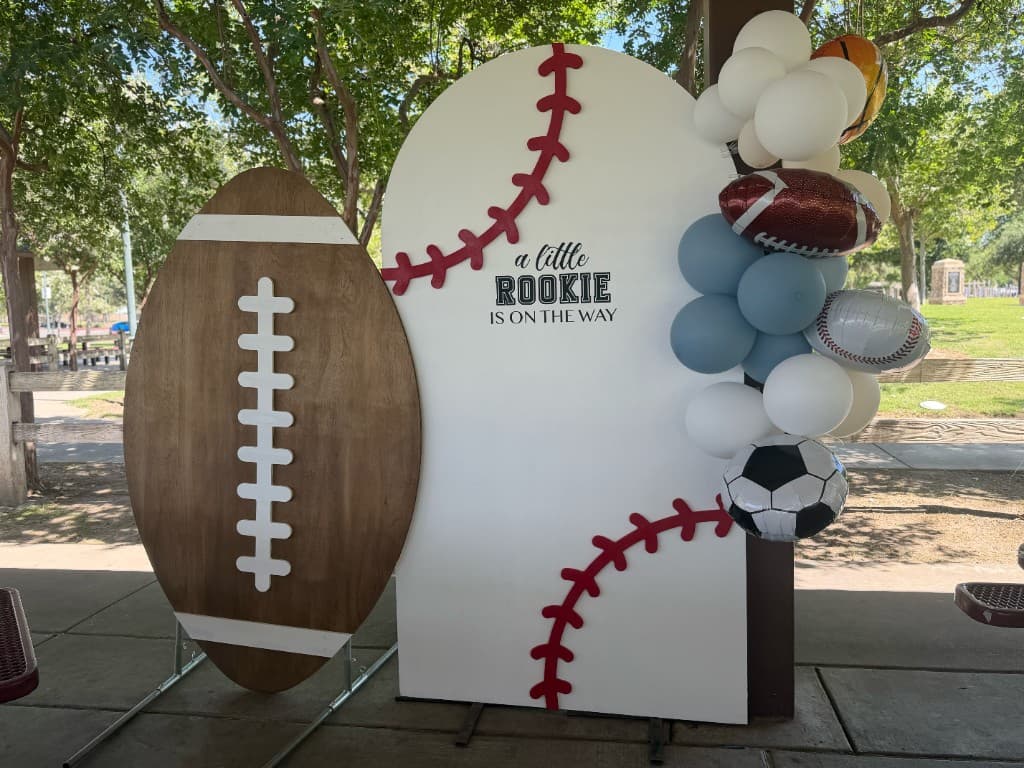 Sports-themed backdrop with balloon garland for a baby shower or gender reveal